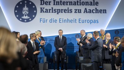 Mario Draghi steht auf der Bühne während das Publikum applaudiert