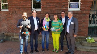Staatssekretärin Andrea MIlz mit Mitgliedern des Solinger Sportbund e.V. vor einer Hauswand.