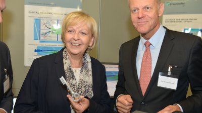 Ministerpräsidentin Kraft betrachtet einen 3D gedruckten Schlüssel mit den Buchstaben RWTH als Schlüsselbart
