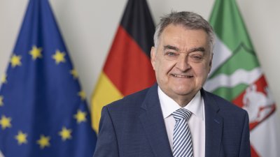 PHB Reul, Herbert - lächelnd, vor Flaggen (2022)