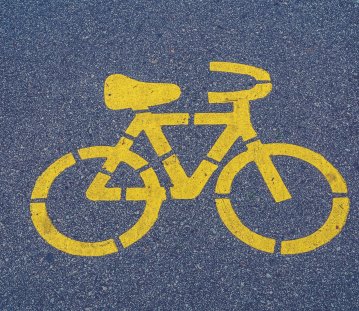 auf Asphalt ist eine gelbe Markierung in Form eines Fahrrades