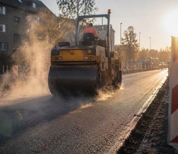 Eine Planierwalze walzt eine Straße