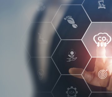 Ein Finger tippt auf ein CO2 Symbol mit Pfeilen runter