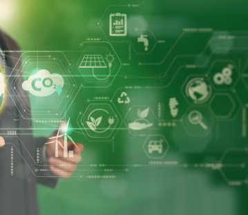 eine Person hält eine Erdkugel in der Hand, drum herum weitere Symbole wie CO2, Recyclingzeichen