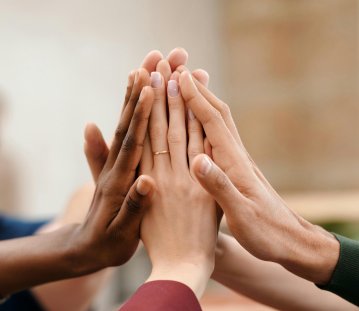 Hände von Menschen unterschiedlicher Herkunft halten zusammen