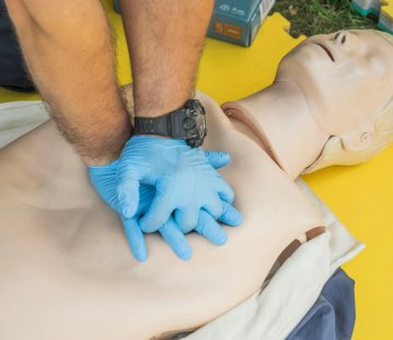 Ein Mann übt an einer Reanimationspuppe