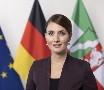 PHB Türkeli-Dehnert, Gonca - leicht lächelnd, vor Flaggen (2022)