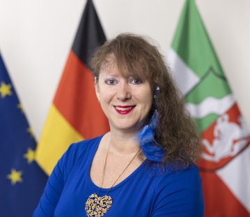 PHB Milz, Andrea - lächelnd, vor Flaggen (2022)