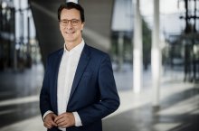 Ministerpräsident Hendrik Wüst lächelt in die Kamera