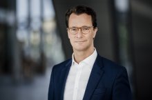 Ministerpräsident Hendrik Wüst lächelt in die Kamera