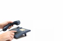 Bild zeigt eine Hand, die die Tatstatur eiens Telefons bedient