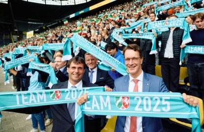 Minister Dr. Optendrenk und Ministerpräsident Wüst in der Fankurve vor künftigen Steuerprofis