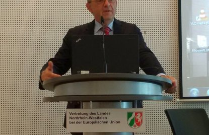 Das Foto zeigt den NRW-Finanzminister bei einer Rede an einem Pult.