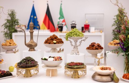 Buffet bei einem Iftar-Empfang, im Hintergund die NRW-Flagge