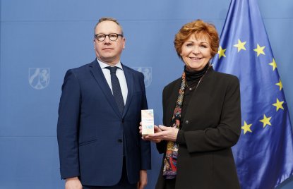 Justizminister Limbach und die Opferbeauftragte Havliza halten eine Packung K.O.-Tropfen-Schutz-Armband in die Kamera