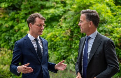 Ministerpräsident Wüst und NATO-Generalsekretär Mark Rutte im Gespräch vor grünem Hintergrund