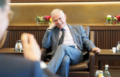 Besprechungssituation in einem festlichen Raum, der Doyen lacht