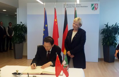 Der Gouverneur der chinesischen Partnerprovinz Jiangsu trägt sich in Anwesenheit von Ministerpräsidentin Kraft ins Gästebuch der Landesregierung ein.