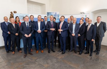 22 Personen stehen vor mehreren Roll-ups des Landes NRW und Einstein-Teleskops