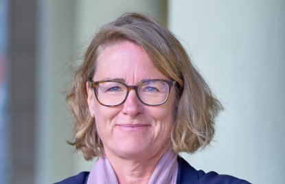 Jennifer Rybarczyk mit blonden Haaren (fast schulterlang), Brille und blauem Blazer