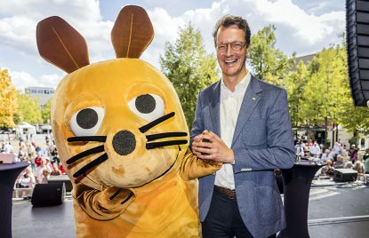MP Wüst scherzt mit der überlebensgroßen WDR-Maus