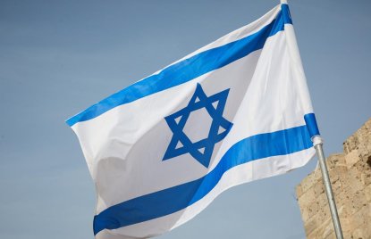 Israel-Flagge vor einem Stück Mauer