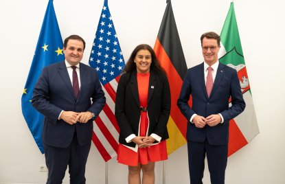 Die Generalkonsulin steht neben dem Ministerpräsidenten und dem Minister Liminski vor den Flaggen der EU, USA, Deutschlands und des Landes Nordrhein-Westfalens.