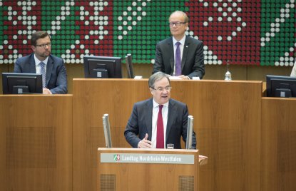 Ministerpräsident Armin Laschet hält seine Rede,vor ihm ein Pult mit 2 silberfarbenen Mikrofonen.