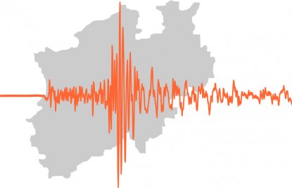 Die Grafik zeigt das Logo des neuen Erdbebenalarmsystems: Eine graue Reliefkarte von NRW im Hintergrund, davor eine orangefarbene Amplitude.