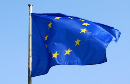 EU-Flagge weht im Wind - Blaue Flagge mit gelben Stermen im Kreis.