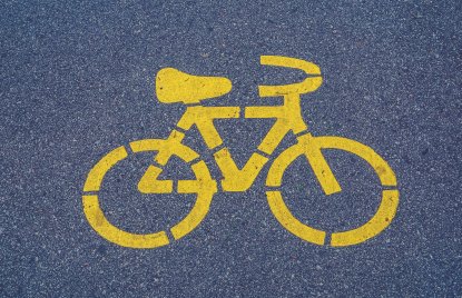 auf Asphalt ist eine gelbe Markierung in Form eines Fahrrades