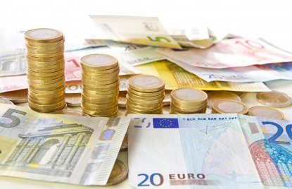 Auf dem Bild zu erkennen sind Euro-Geldscheine sowie aufgetürmte Euro-Münzen.