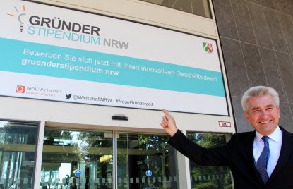  Wirtschaftsminister Pinkwart rechts unten im Bild zeigt lächelnd auf das Gründerstipendium NRW.