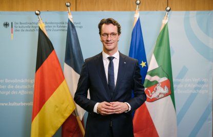 Porträtfoto vor Flaggen