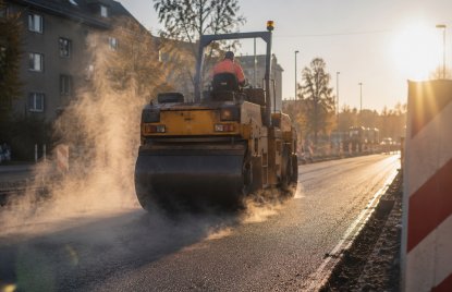 Eine Planierwalze walzt eine Straße