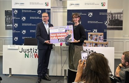 Der Minister der Justiz Dr. Benjamin Limbach und Yanni Gentsch halten den Petitions-Banner für die Kameras hoch