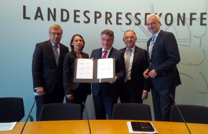 Vertreter des Bündnisses halten das Memorandum in die Kamera. 