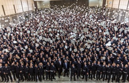 Polizistinnen und Politzisten werfen nach Vereidigung ihre Hüte