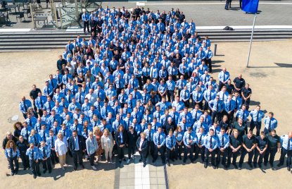 Ein Gruppenfoto aus der Vogelperspektive von den Absolventinnen und Absolventen in blauen Uniformen