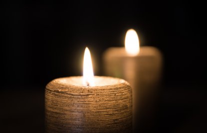 zwei helle Kerzen leuchten vor einem schwarzen Hintergrund