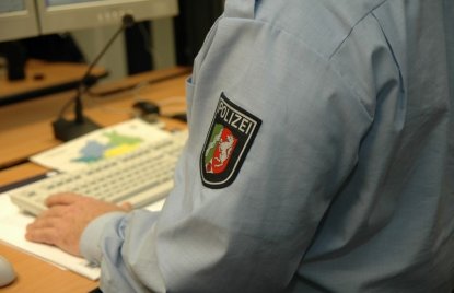 Polizist vor Tastatur in Leitstelle