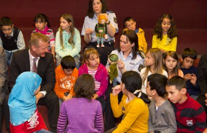 Das Foto zeigt Minister Jäger inmitten von Kindern und 2 Polizistinnen, die Verkehrssicherheitspuppen präsentieren.