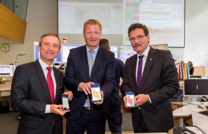Oberbürgermeister der Stadt Düsseldorf Thomas Geisel, Innenminister Ralf Jäger und Präsidenten des Bundesamtes für Bevölkerungsschutz und Katastrophenhilfe, Christoph Unger stehen nebeneinander und präsentieren die Notfall-, Informations- und Nachrichten-App NINA auf dem Mobiltelefon