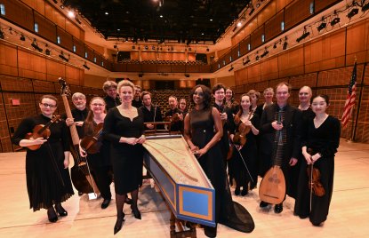 Ministerin Brandes steht mit den Musikerinnen und Musikern von Concerto Köln auf der Konzertbühne