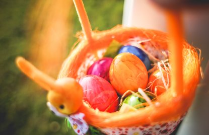 Das Foto zeigt einen Osterkorb mit bunten Ostereiern.