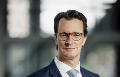 Ministerpräsident Hendrik Wüst lächelt in die Kamera