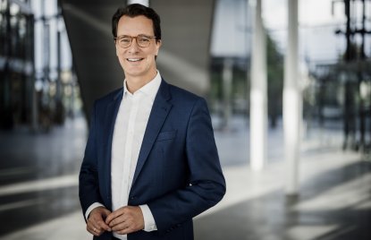 Ministerpräsident Hendrik Wüst lächelt in die Kamera