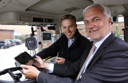Minister Duin sitzt in einem Traktor mit einem Tablet in der Hand neben Torben Calenberg