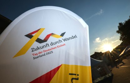 Ein Banner weht im Sonnenuntergang mit dem Schriftzug "Zukunft durch Wandel"