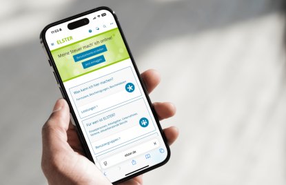 Eine Hand hält ein Handy, darauf zu sehen die „MeinELSTER+“-App